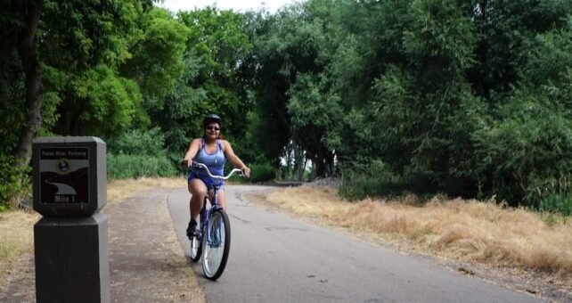 Provo, Utah, resident Veronica Hernandez takes a summer-morning ride along the Provo River Parkway. The 15.2-mile rail-trail is also popular with walkers and runners. | Photo by Cindy Barks