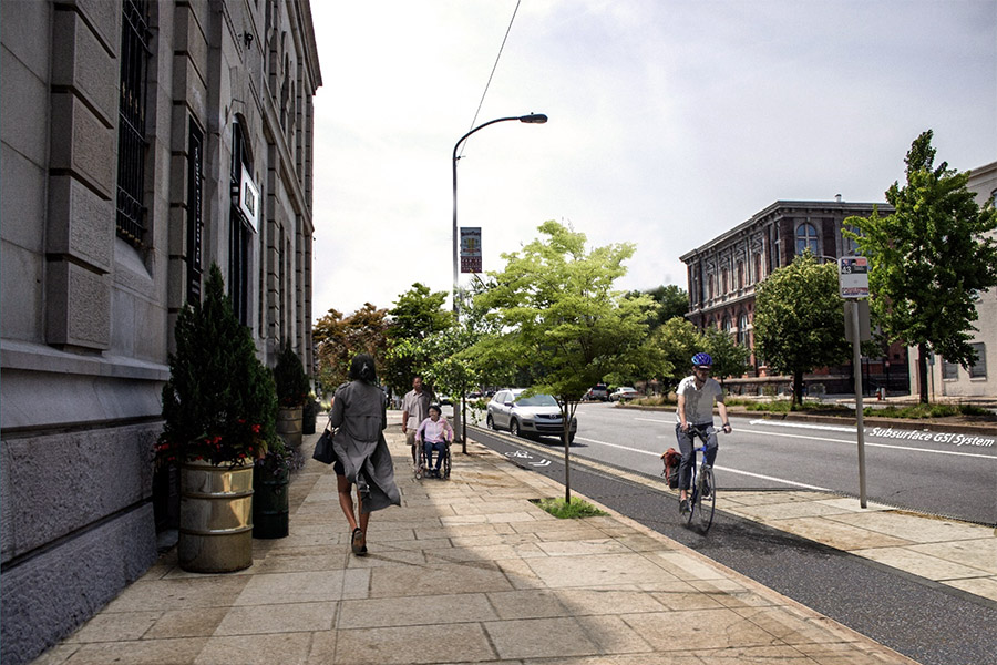 Rendering of how a curbside bikeway might look on Spring Garden St, protecting cyclists from traffic by both parked cars and curb separation. This includes space for people walking, getting in and out of buses and vehicles, people making deliveries, preserves existing trees, and incorporates green stormwater infrastructure. Renderings by Philadelphia City Planning Commission.